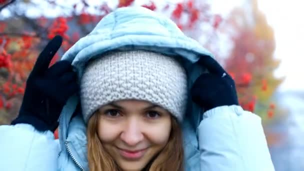 Lady takes off warm jacket hood at rowan tree red berries — Stock Video