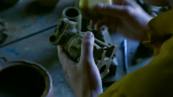 Closeup woman cleans clay sculpture with special sponge — Stock Video