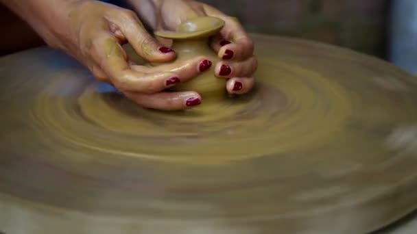Движение от девушки, делающей глиняный горшок к гончарной ленте колеса — стоковое видео