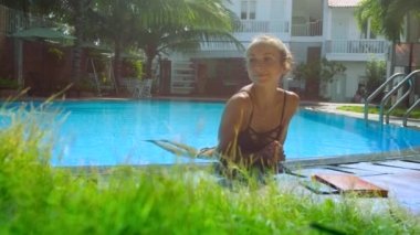Sevimli sarışın kız bikini bariyer eğilerek havuzu aittir
