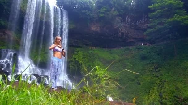 Chica fija palo para teléfono inteligente contra la cascada maravillosa — Vídeos de Stock