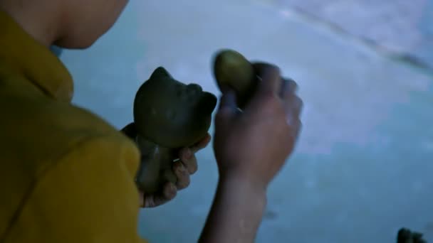 Вид ззаду гончар обробляє виробництво глиняної іграшки — стокове відео