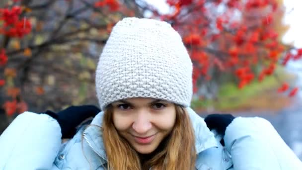 La ragazza si mette il cappuccio e si nasconde sotto a albero di sorbo bacche rosse — Video Stock