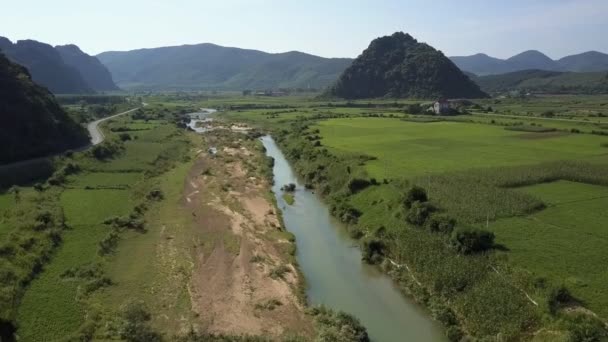 Bovenste deelvenster rivier slingert zich tussen velden in vallei door heuvels — Stockvideo