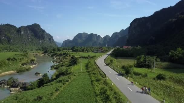 Upper view bikers ride bicycles along road near narrow river — Stock Video