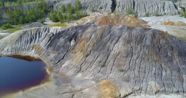 趣のある素敵な空撮は 明るい夏の日の湖鏡水によって放棄された粘土の採石場の斜面します — ストック動画