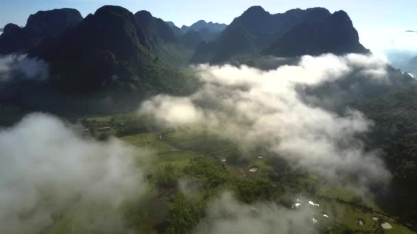 Vuelo sobre el valle de las tierras altas apenas escondido con nubes de niebla — Vídeos de Stock