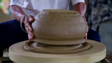 closeup potter adam metal halka ile büyük seramik gemi biler
