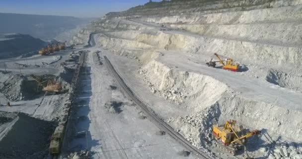 Movimiento aéreo sobre el yacimiento minero con excavadoras y tren — Vídeos de Stock