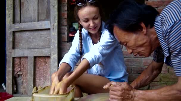Mester kijavítja a lány turisztikai agyagedényt leckét workshop — Stock videók