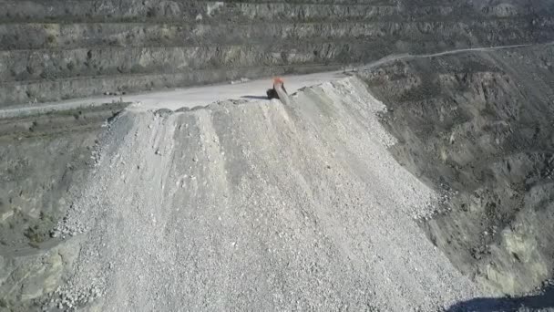 Aerial view tipper truck pours ground on asbestos pit hill — Stock Video