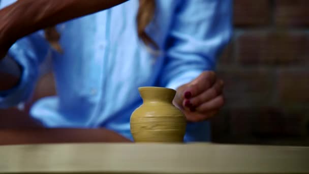 Closeup potter shows woman patterns making on raw clay pot — Stock Video