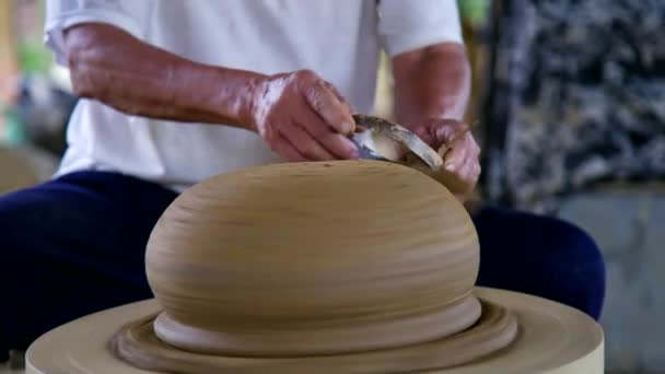 Closeup asian potter grinds big ceramic pot with metal ring — Stock Video
