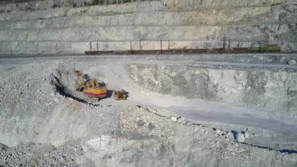 Excavator digs asbestos rock to load dump truck bodywork — Stock Video
