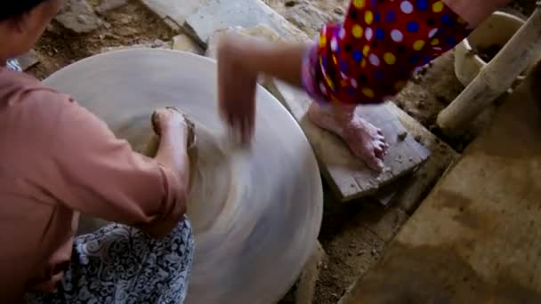 Barefoot assistent aardewerk wiel draait en kneedt klei — Stockvideo