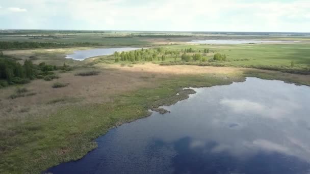 Wody jeziora lustro odbija błękitne niebo chmury na zielone łąki — Wideo stockowe