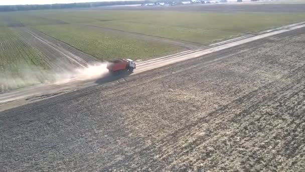 Flycam sigue camión con patatas que conducen a lo largo de camino tierra — Vídeo de stock