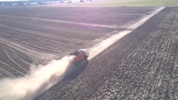 Drone vuela sobre camión con patatas levantando nubes de polvo — Vídeo de stock