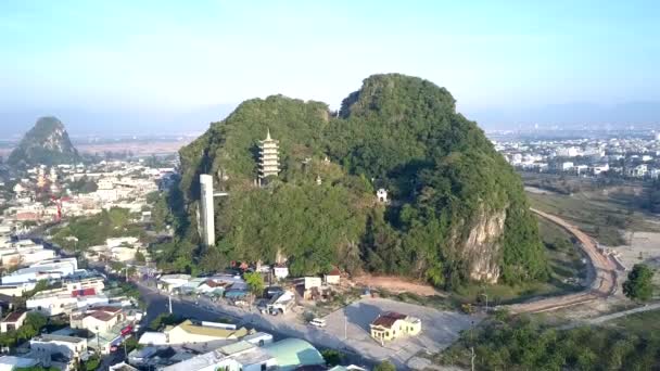 Vista aérea sola colina verde con templo entre la ciudad — Vídeo de stock