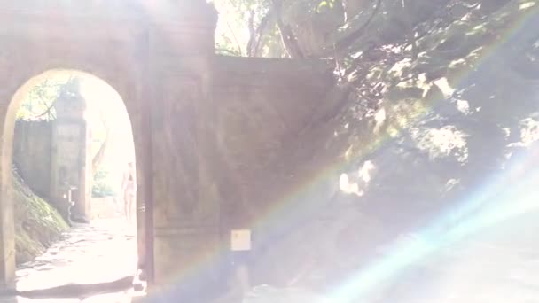 過去の古い石造りのゲートと洞窟から歩く若い女性運動 — ストック動画