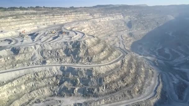 Aerial motion over deep asbestos quarry with mining machines — Stock Video