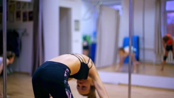 स्लिम सुनहरे बालों वाली लड़की पट्टी पोल नृत्य प्रशिक्षण पर शरीर झुकती है — स्टॉक वीडियो