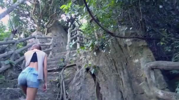 Meisje klimt oude trap met leuningen in tropische park — Stockvideo