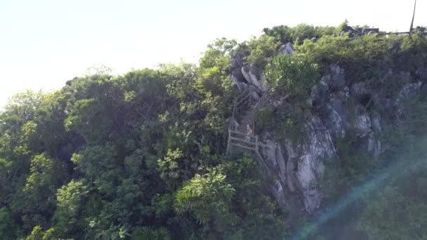 Повітряний зелений пагорб і дівчина фігура відпочиває на кам'яних сходах рейки — стокове відео
