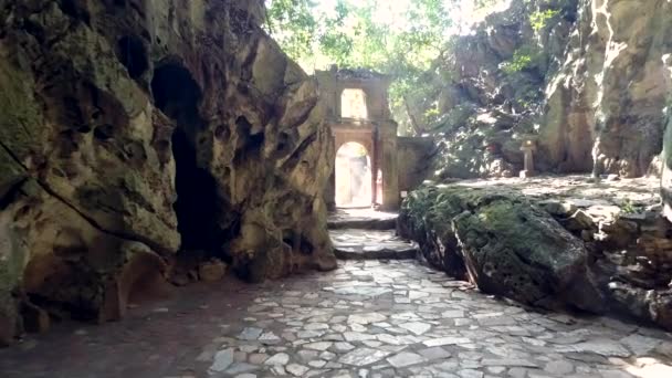 Movimento ao longo de paredes de pedra ao arco antigo na caverna de mármore — Vídeo de Stock