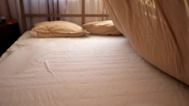 Person shakes blanket like sail and puts on double bed — Stock Video