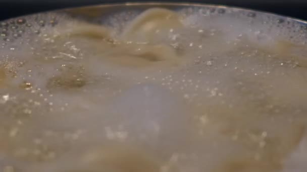 Makro vody zurčivě stéká s pěnou, když knedlíky vařit v pánvi — Stock video