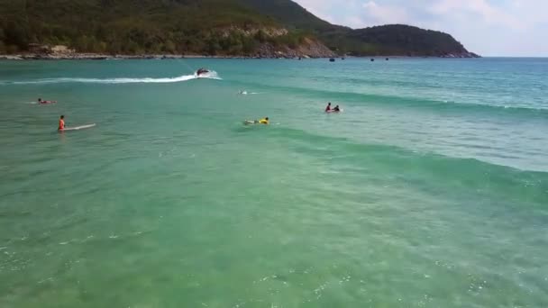 Surfers που πλέουν στα διοικητικά συμβούλια, κοντά στην παραλία εναντίον οδήγησης σκούτερ νερό — Αρχείο Βίντεο