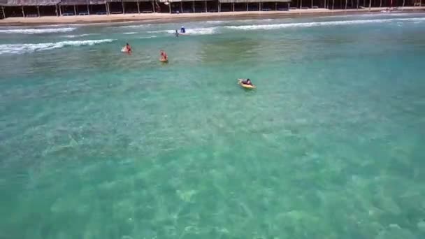 Vista superior do oceano em surfistas iniciantes navegando pela praia — Vídeo de Stock