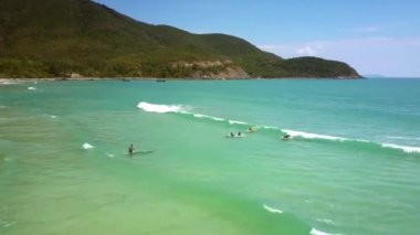 Hızlı uçuş masmavi okyanus plaj kum sörfçü ile yukarıda