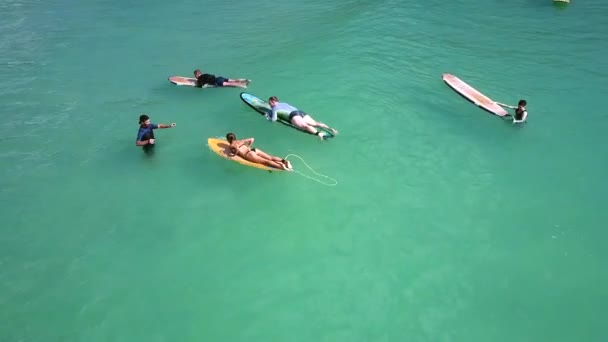 Entrenador ayuda chica paddle board con las manos en la onda — Vídeos de Stock