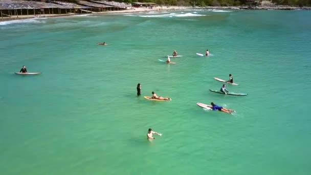 Coach uczy dziewczyna w czerwonym bikini wśród studentów na ocean — Wideo stockowe