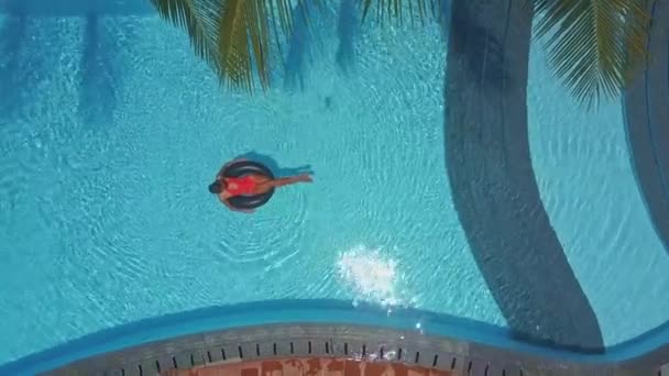 Бассейн роскошного курорта и женщина плавает на кольце — стоковое видео