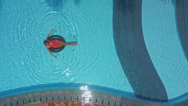Дівчина добре проводить час, плаваючи на буї в басейні — стокове відео