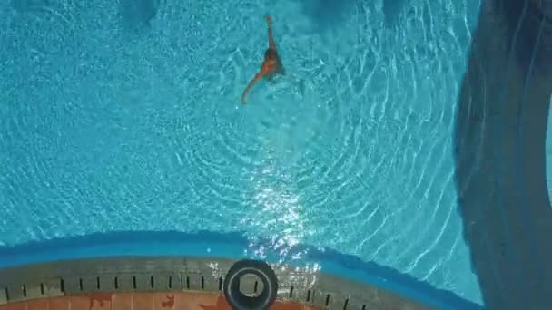 Дама стоит в бассейне и делает круги по воде — стоковое видео