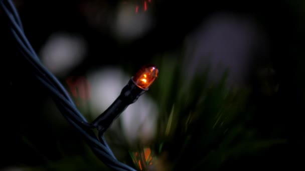 Macro cámara lenta guirnalda luz roja parpadea en el árbol de Navidad — Vídeos de Stock