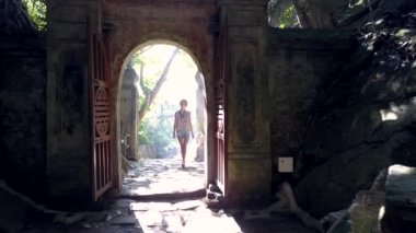 Kız Turizm taş kemer ışık karşı mağaraya girer 