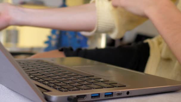 stock video slow motion woman rolls up sleeve sitting by laptop at table