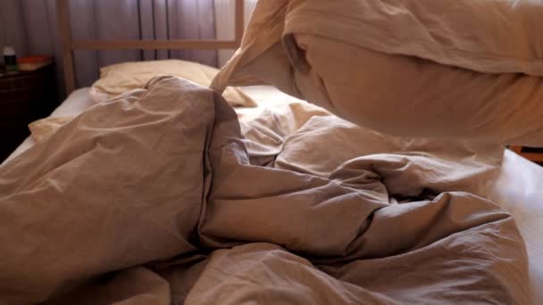 Homem joga travesseiros sacode cobertor e coloca na cama de casal — Vídeo de Stock