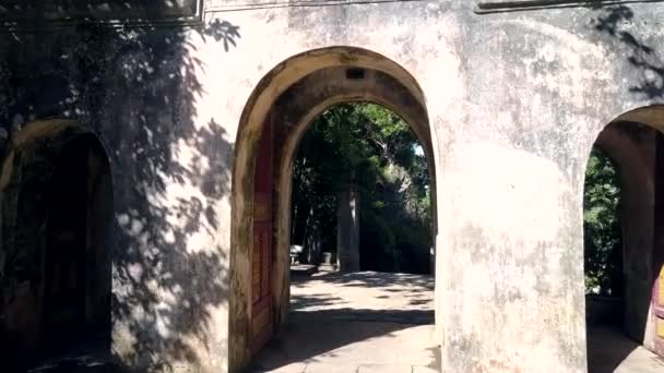Motion through old stone arch to temple internal yard — Stock Video