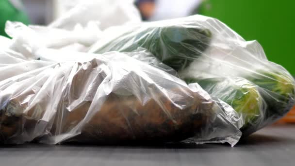 Macro verse wortelen komkommers in zakken aan de kassier Bureau liggen — Stockvideo