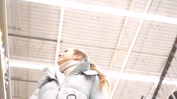 Slow-motion shot lage hoek vrouw wandelingen langs de winkel rekken — Stockvideo