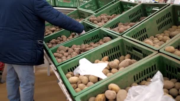 Stäng Visa kunden sätter potatis i disponibel påse — Stockvideo