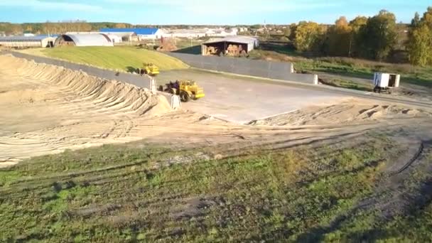 Aerial flygning över enorma ensilage gropar med maskiner — Stockvideo