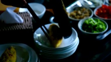 kişi kase malzemelerle plaka omlet koyar