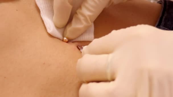Slow motion closeup master wipes skin around belly ring — Stock Video
